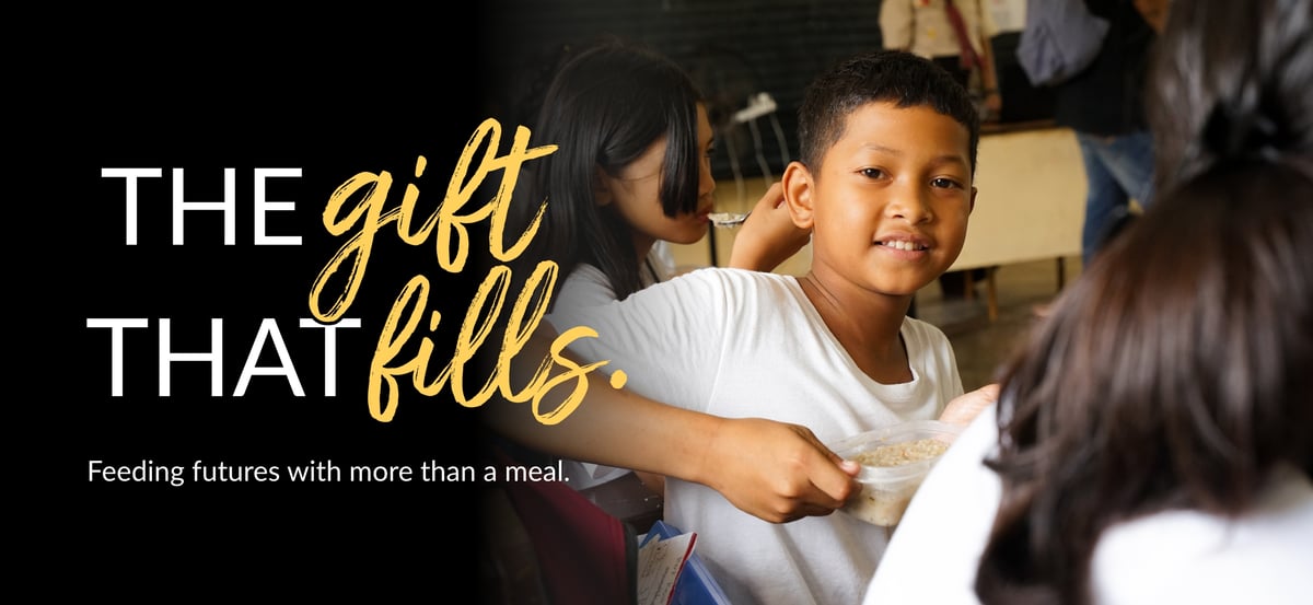 Email header image with "The Gift That Fills" wordmark and the tagline "Feeding futures with more than a meal." The photo is of a child holding a Rise Against Hunger meal.