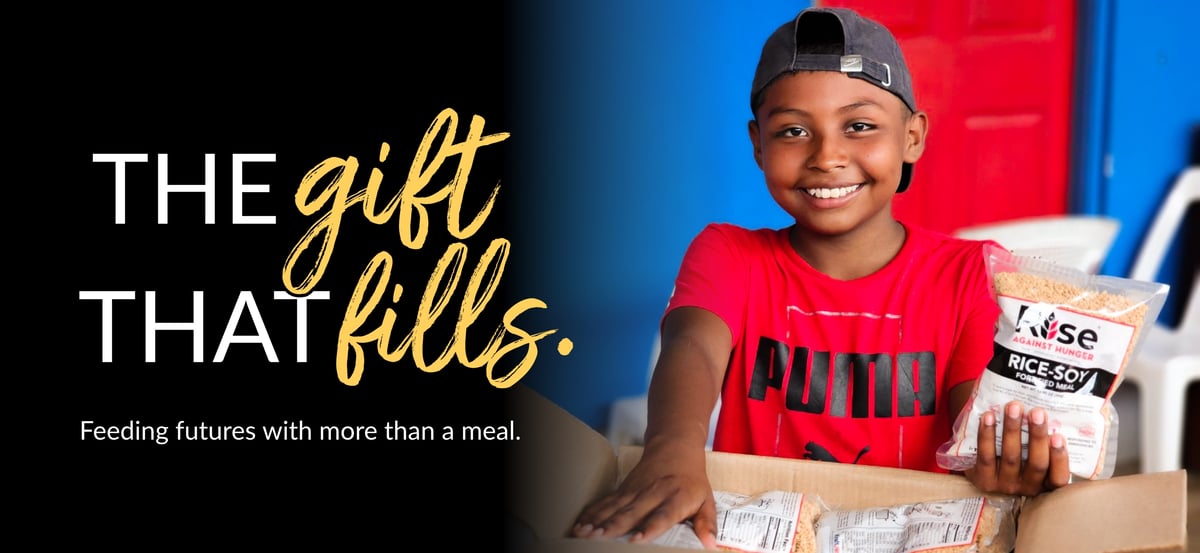 Email header image with "The Gift That Fills" wordmark and the tagline "Feeding futures with more than a meal." The photo is of a child holding a Rise Against Hunger meal.