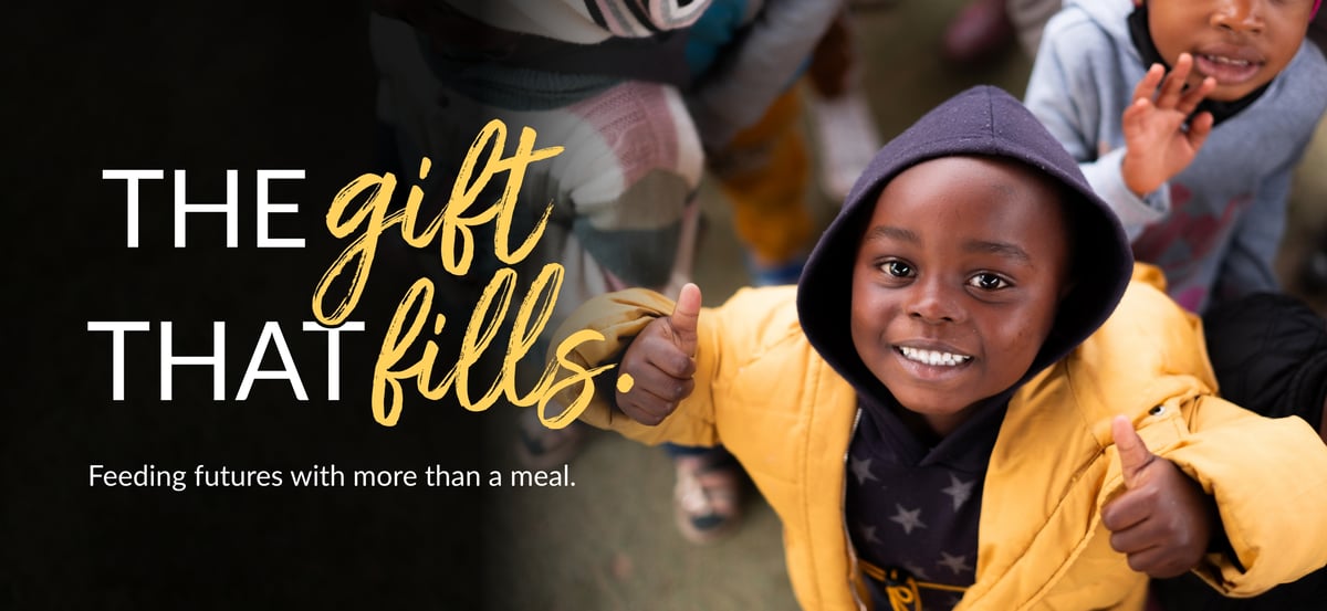 A child with two thumbs up for Rise Against Hunger! Text overlaid: The gift that fills. Feeding futures with more than a meal. 