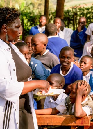 A teacher passing out Rise Against Hunger meals to her students.