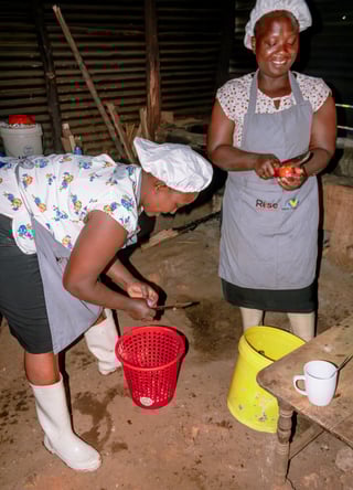 Women cutting produce to prepare meals.